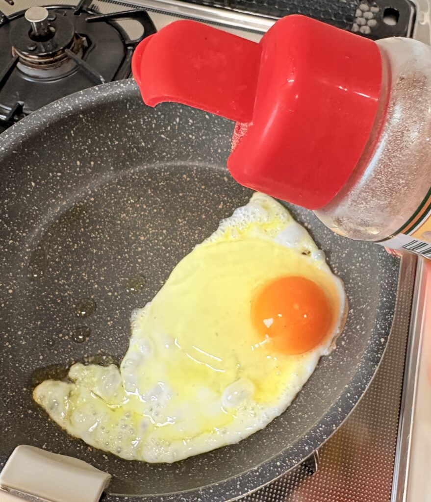 目玉焼きにマキシマムをかけているイメージ画像